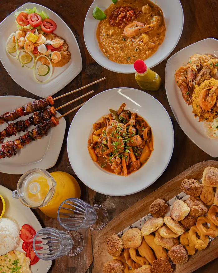 Mesa servida del rancho con pinchos, guisado, camarones y hojaldres