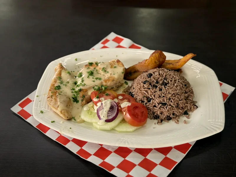 Pechuga a la plancha con salsa blanca, arroz con frijoles, ensalada y tajadas