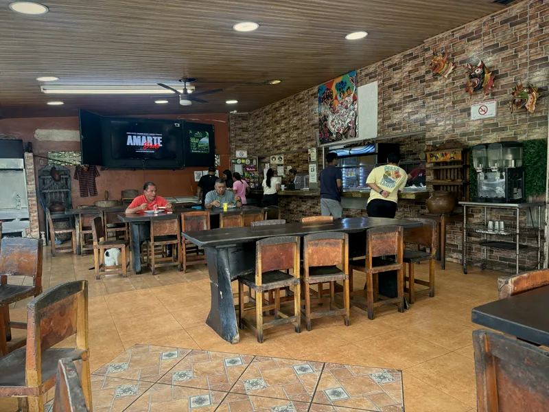 El comedor del rancho con sus mesas de madera y la barra de la vitrina al fondo