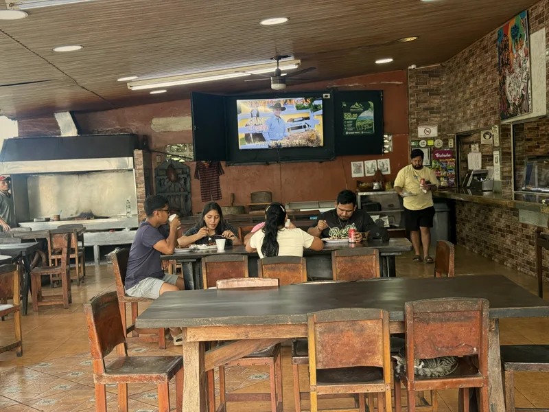 El comedor de El Rancho Interiorano en Loma Campana con clientes almorzando, bajo el techo de madera